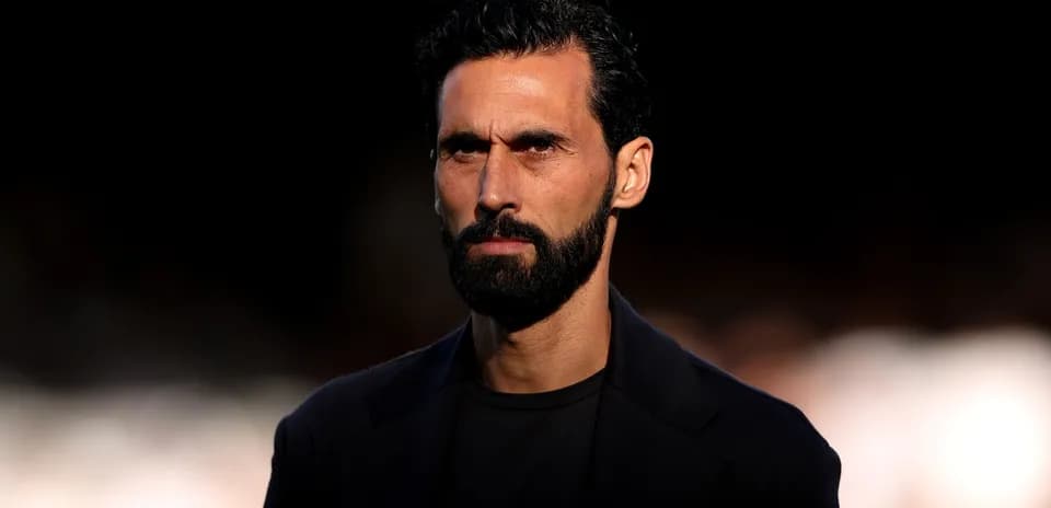 Man with beard and serious expression in dark attire