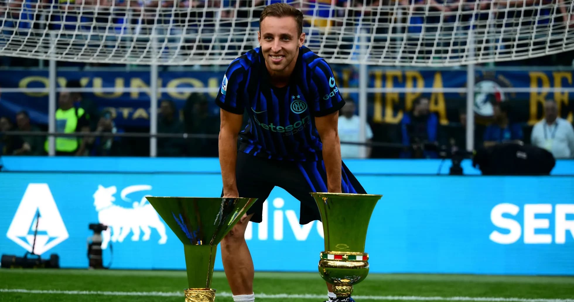 Futbolchi ikki kubok bilan maydonda turibdi