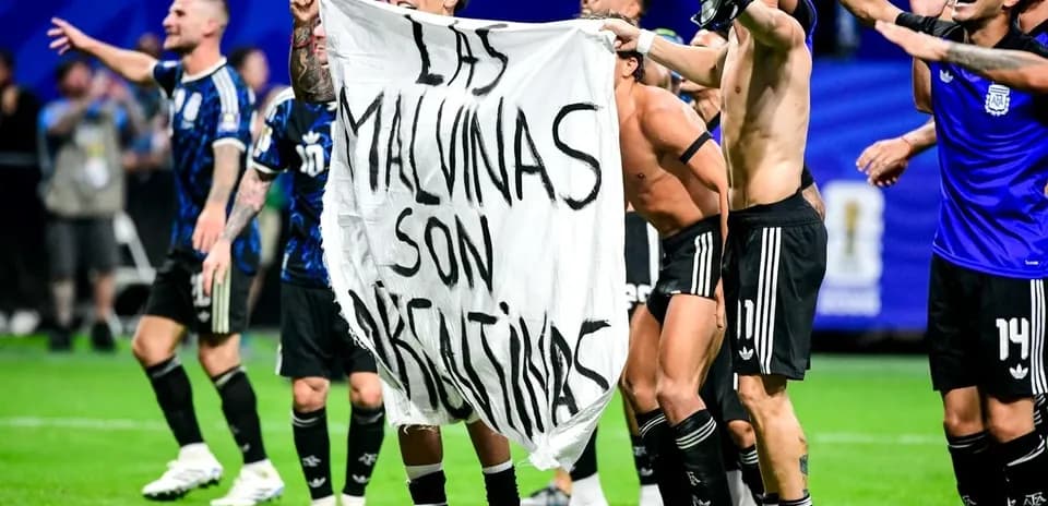 Futbolchilar bayroq ushlab, nishonlashmoqda