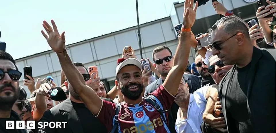Futbolchi muxlislarga qo'l silkitmoqda