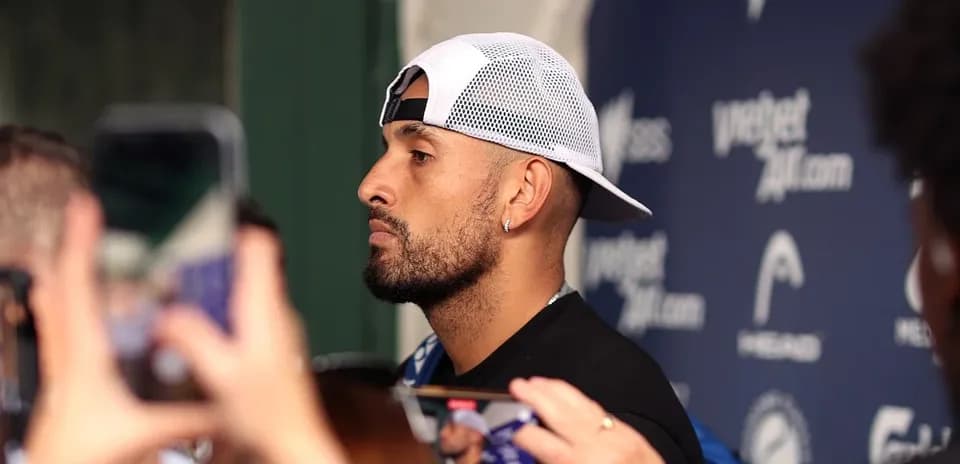 Athlete speaking at press conference surrounded by fans