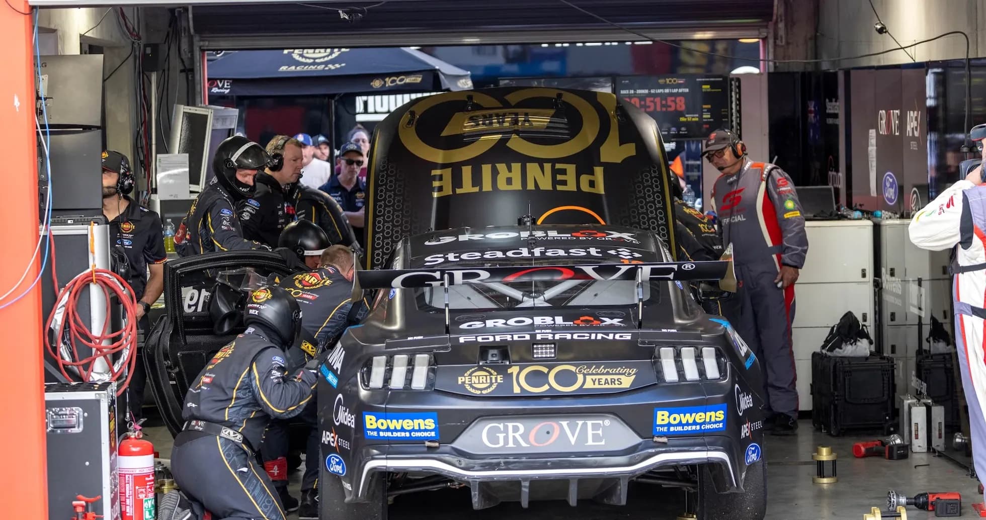 Pit crew working on race car in garage