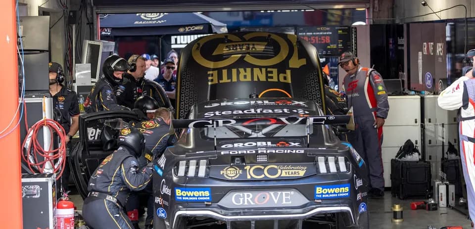 Pit crew working on race car in garage