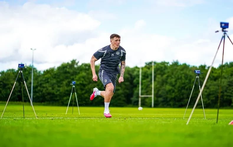 O'yinchi trening maydonida yugurayotgan holatda