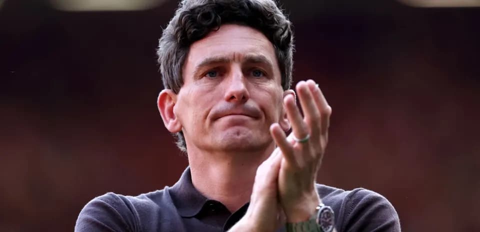 Men's football coach applauding in stadium