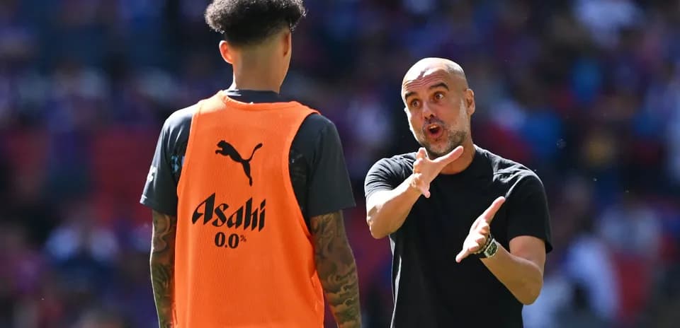Trener futbolchi bilan taktik masalalarni muhokama qilmoqda