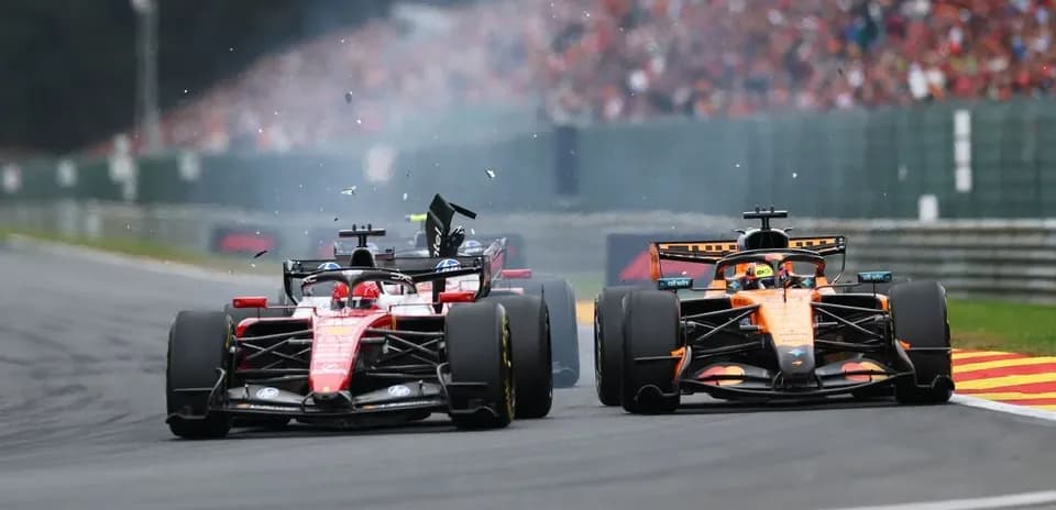 Ferrari and McLaren cars racing with debris flying