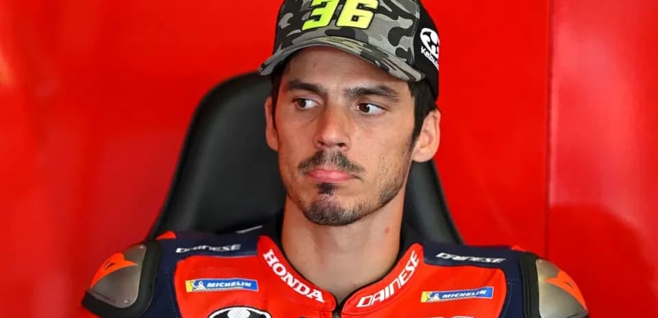 Motorsport athlete in racing gear sitting in garage