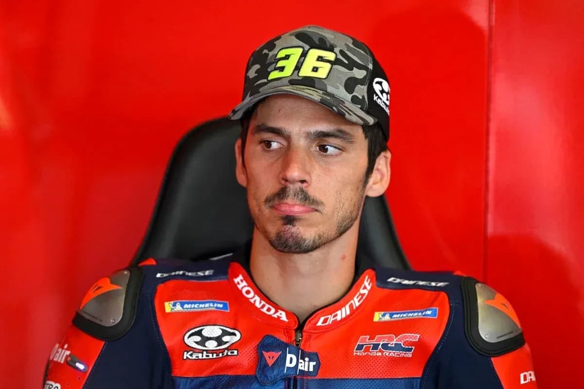 Motorsport athlete in racing gear sitting in garage