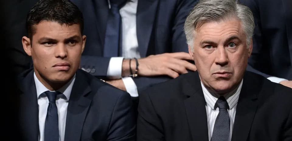 Two men seated in formal attire during event