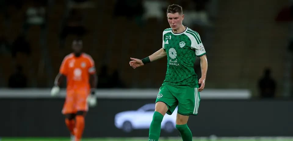 Futbolchi to'pni ushlab, raqibga qarab turibdi