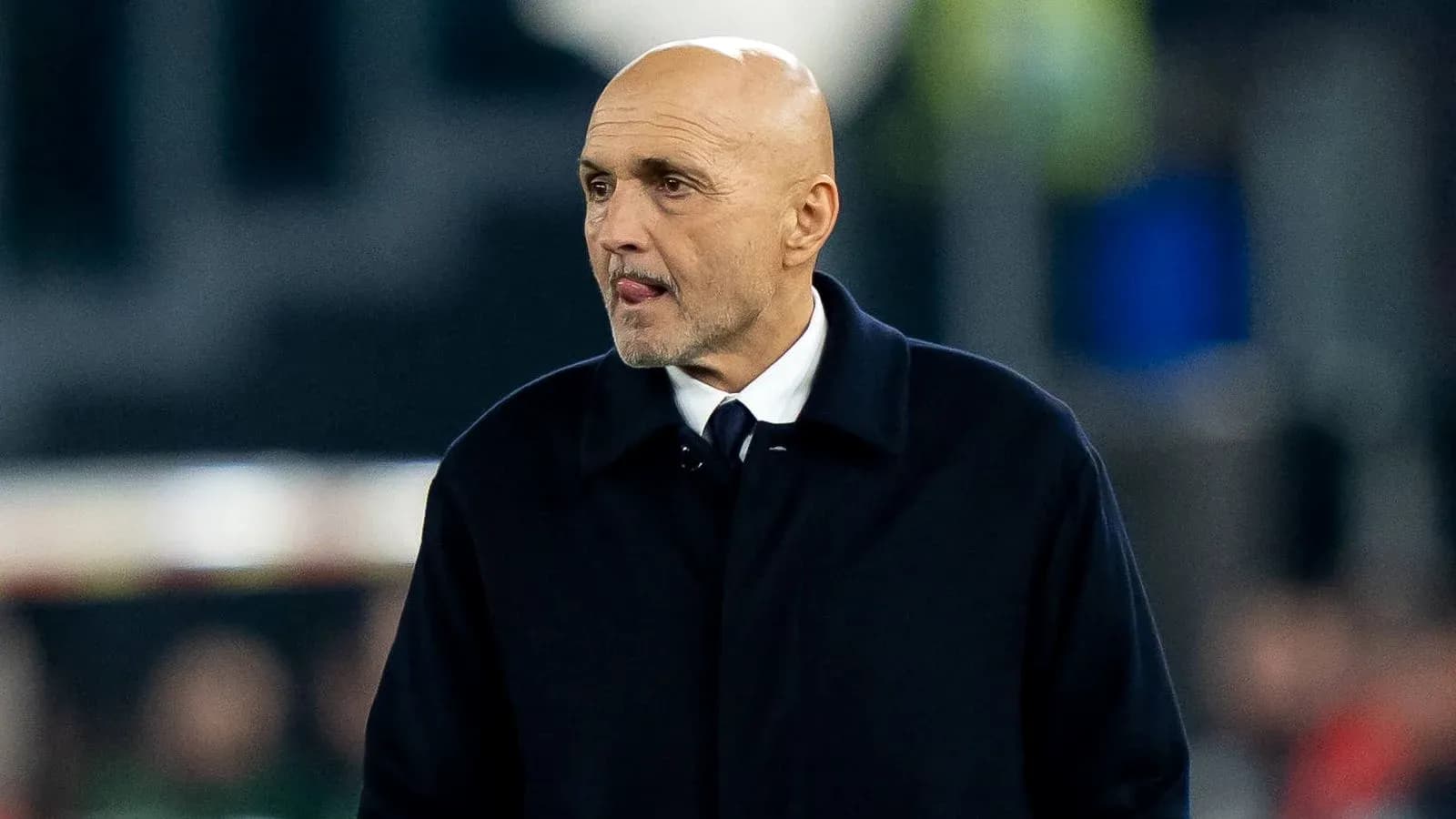 Bald coach walking on the sideline during match