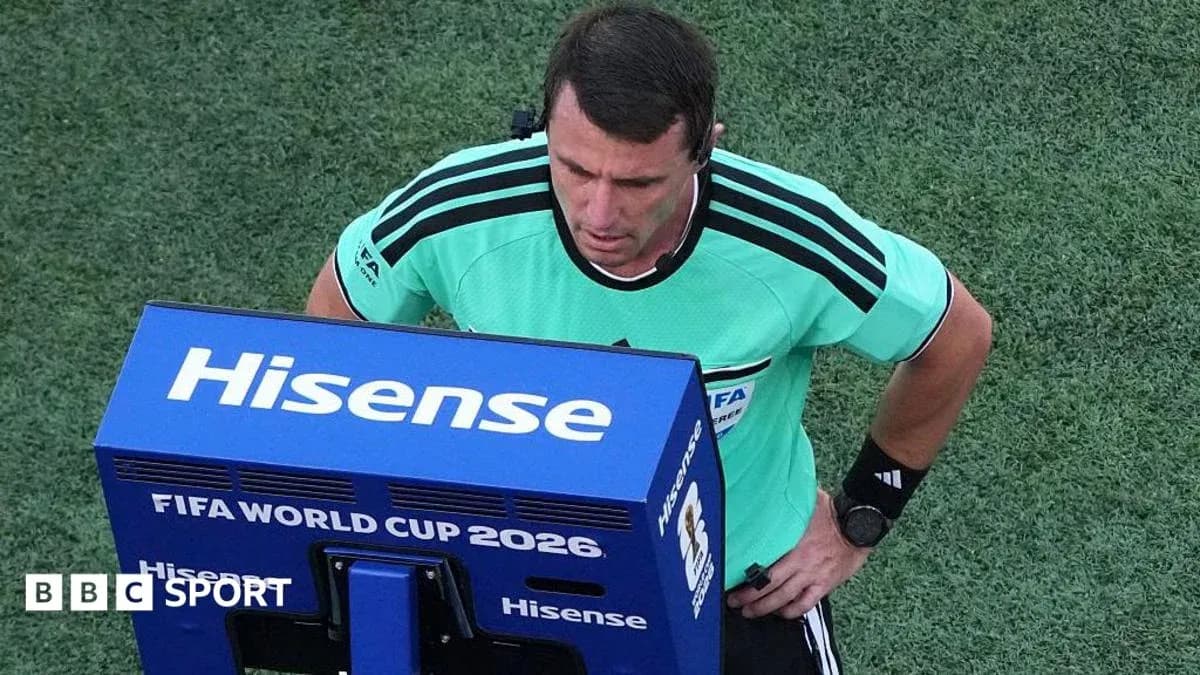 Referee reviewing decision on VAR monitor during match Referee reviewing decision on VAR monitor during match