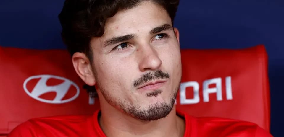 Futbolchi qizil forma bilan o'yin benchida