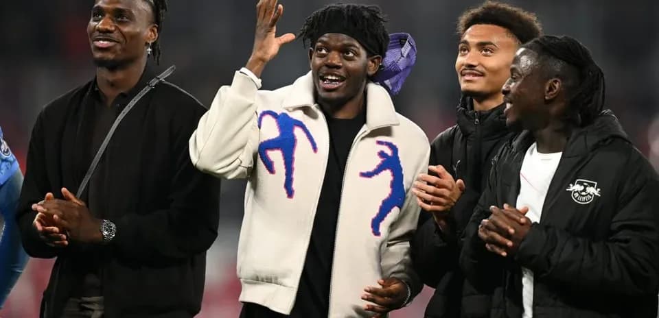 Four football players celebrating together on field