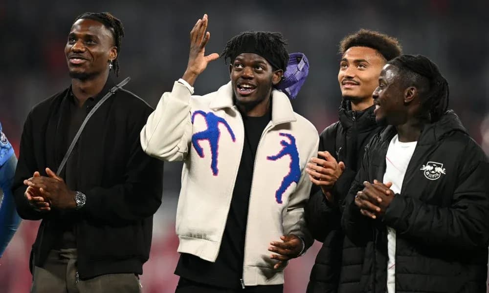 Four football players celebrating together on field