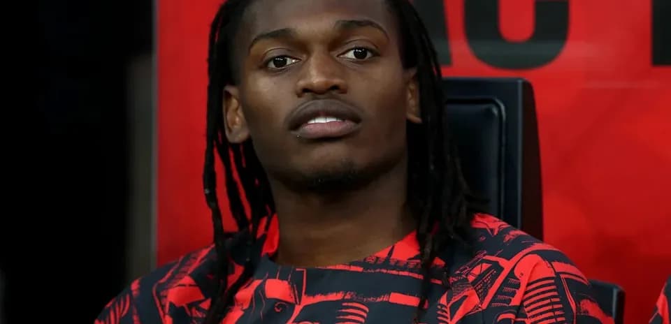 Futbolchi benchda o'tirgan, AC Milan formasi kiygan