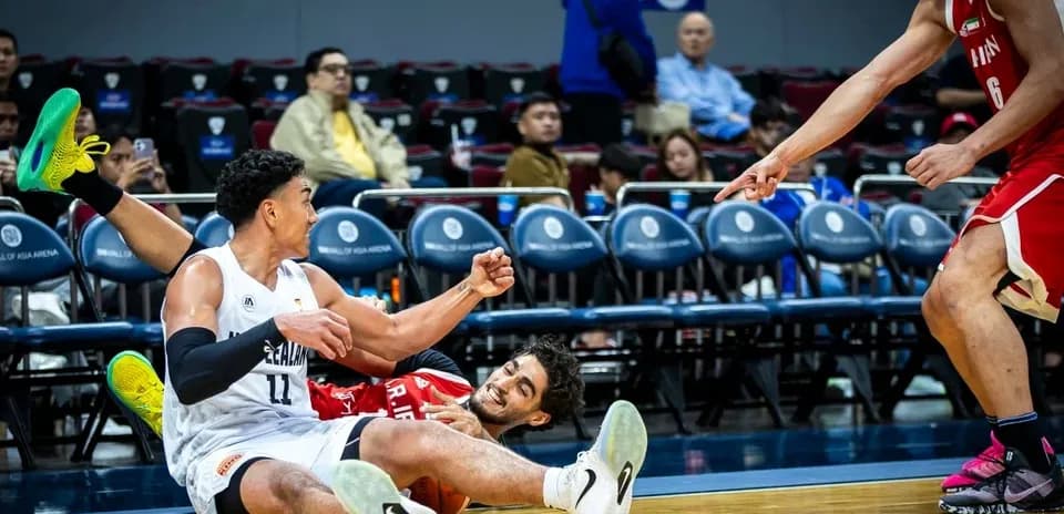 Two players on the floor competing for the ball