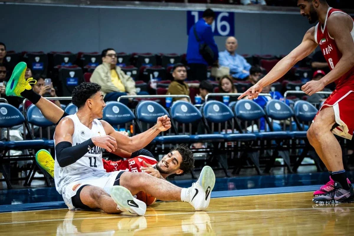 Two players on the floor competing for the ball