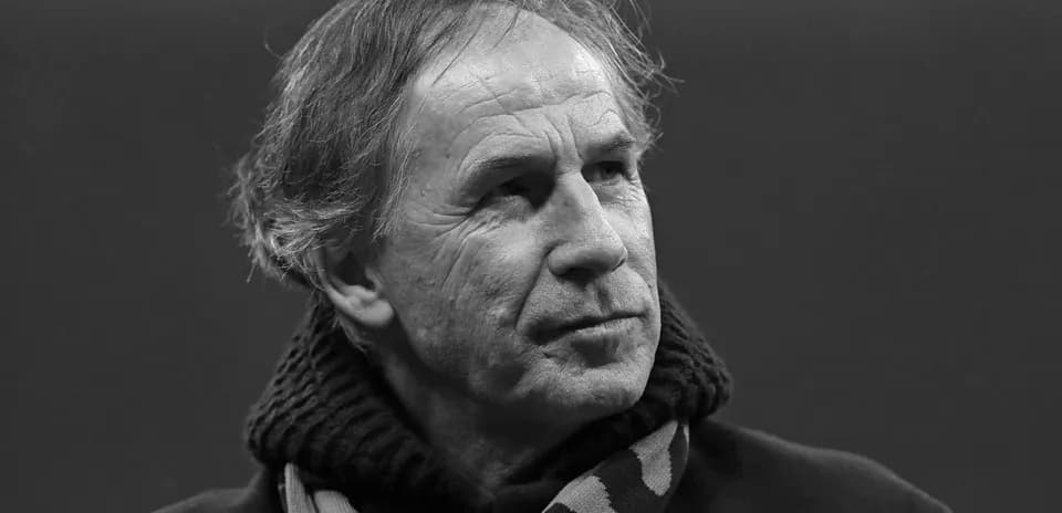 Man wearing a scarf, looking thoughtfully