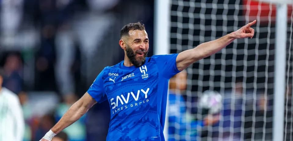 Futbolchi gol urganidan so'ng qo'lini ko'tarib turibdi
