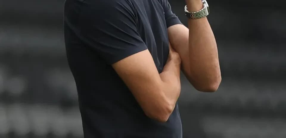 Coach observing the match with arms crossed
