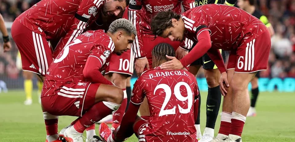 Liverpool players supporting injured teammate on field