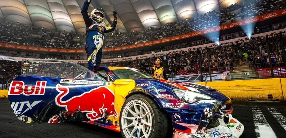 Drifter celebrating victory on car in arena