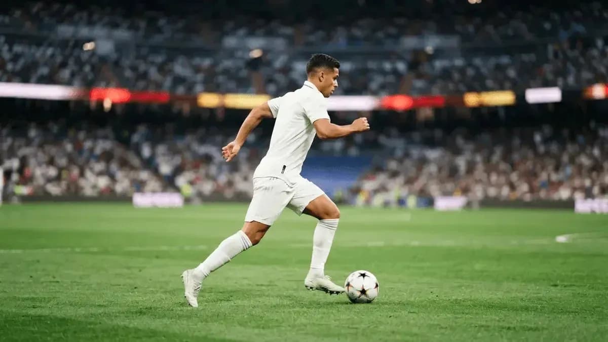 Futbolchi to'p bilan maydon bo'ylab yugurmoqda Futbolchi to'p bilan maydon bo'ylab yugurmoqda