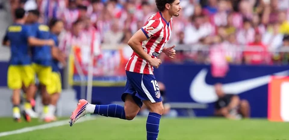 Futbolchi maydonda yugurayotgan, atletik ko'ylakda