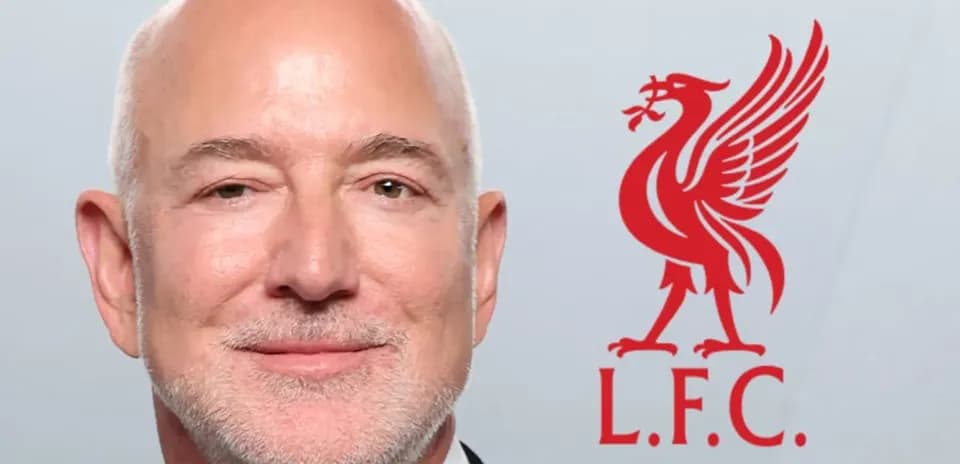 Man smiling next to Liverpool FC logo