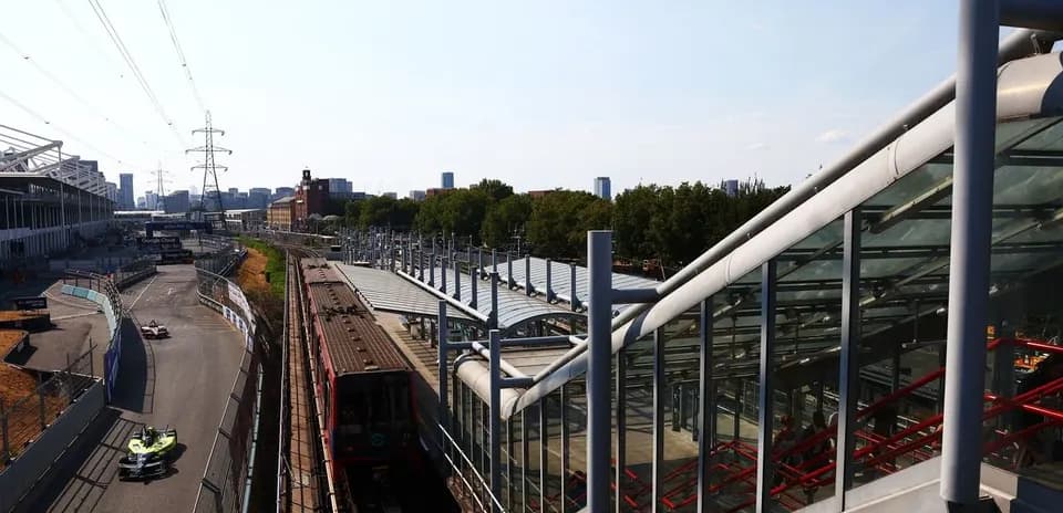 Formula E car racing near train station in city
