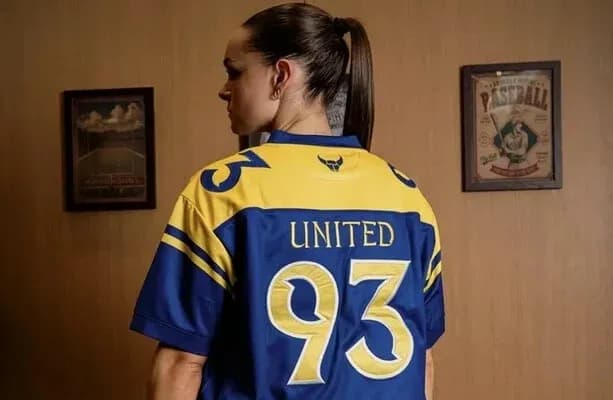 Woman wearing blue and yellow jersey with 'UNITED' and number 93