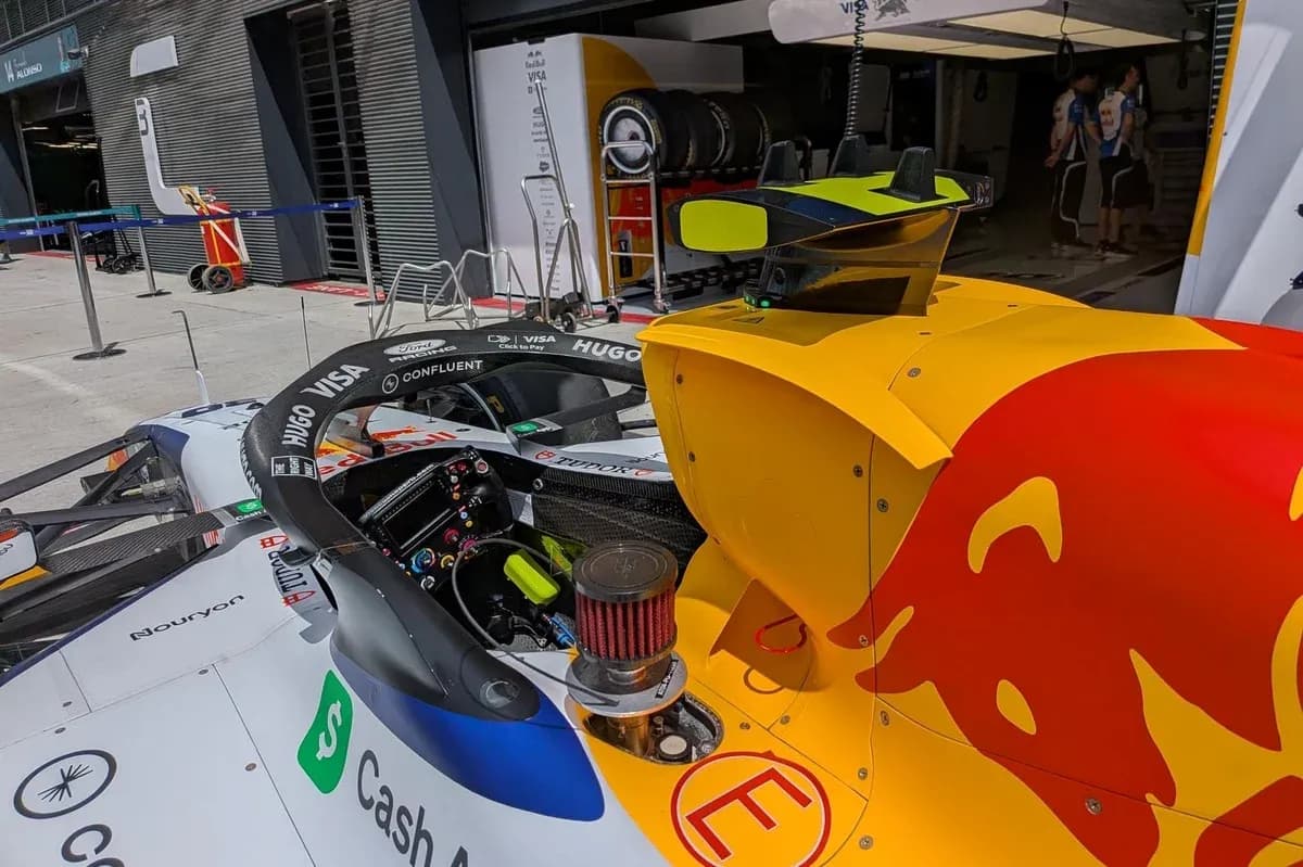 Formula 1 car in pit area with team equipment