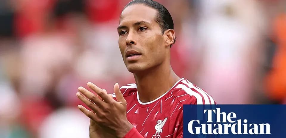 Futbolchi Liverpool formasida maydonda qo'llarini birlashtirgan