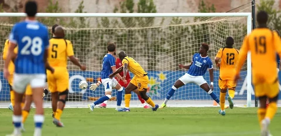 Football players in action near goal during match