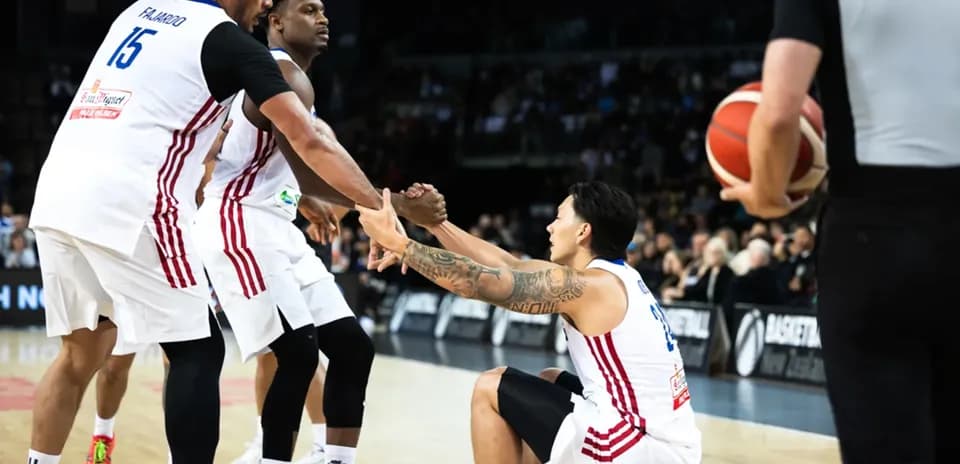 Two players assisting teammate getting up during game