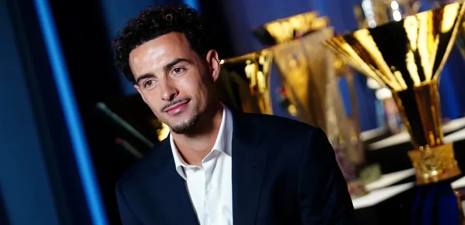 Player seated in front of trophies at event