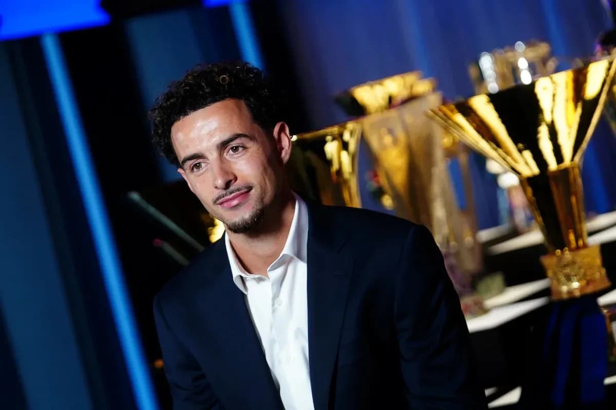 Player seated in front of trophies at event