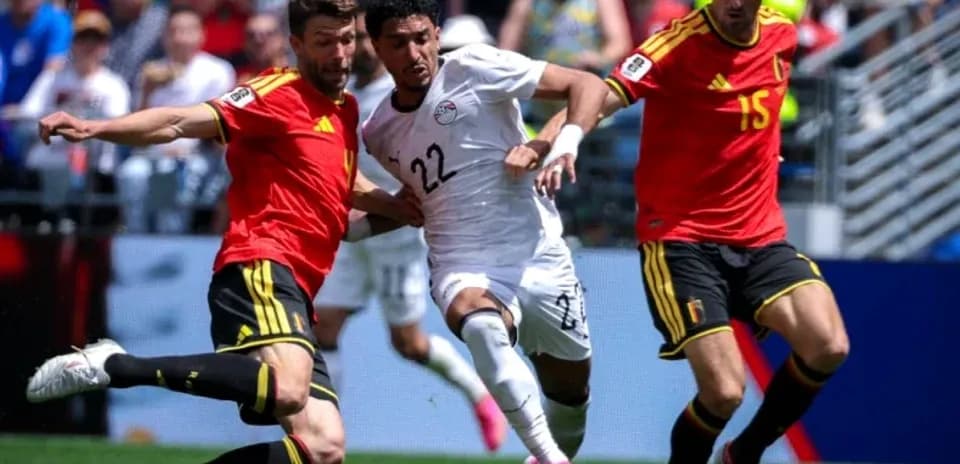Two players tackling an Egyptian player during match