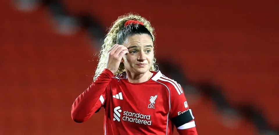 Futbolchi LFC formasida, maydonda turgan ayol