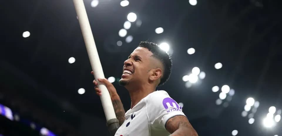 Futbolchi bayroq bilan maydonda nishonlayapti
