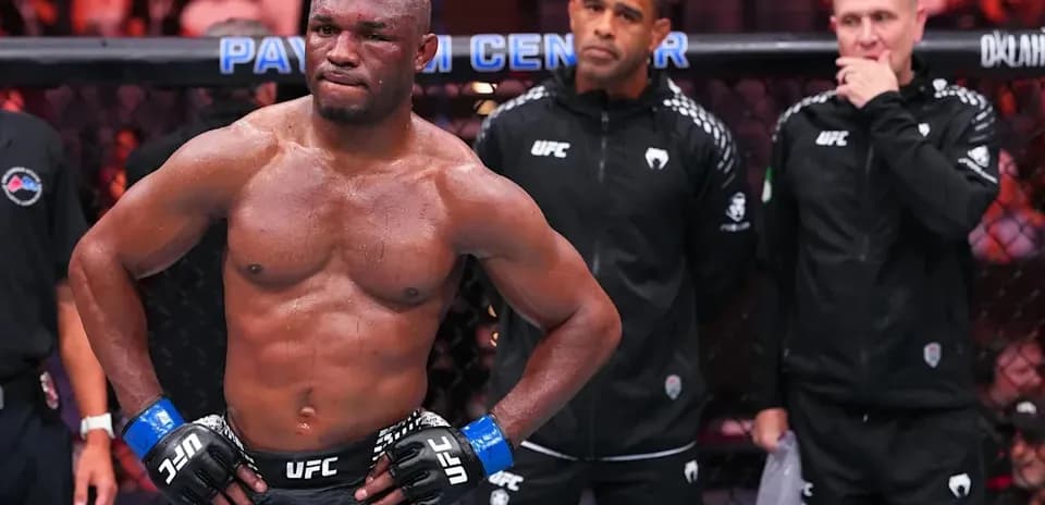 Fighter in octagon with coaches observing behind
