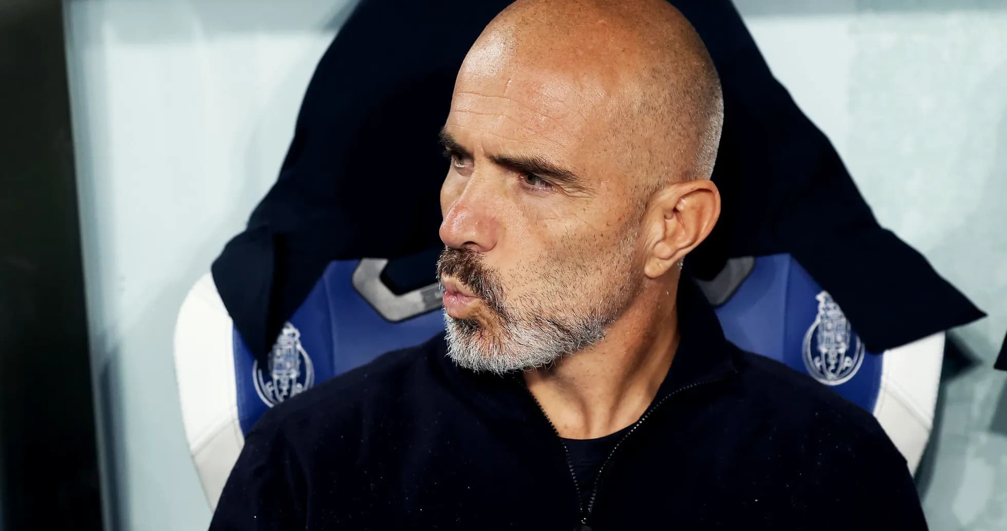 Bald coach sitting on the bench during match