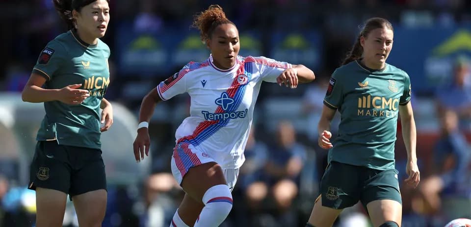 Three female football players in action during match