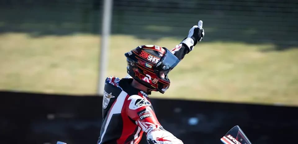 Motorsport athlete celebrating with raised hand