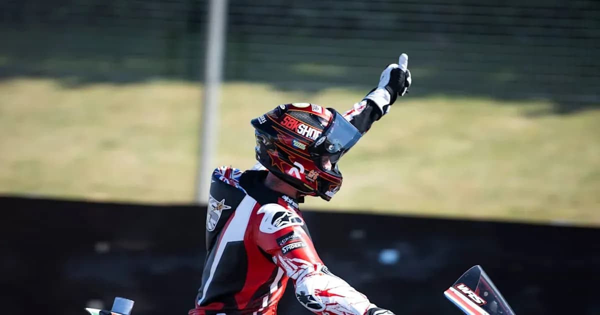Motorsport athlete celebrating with raised hand