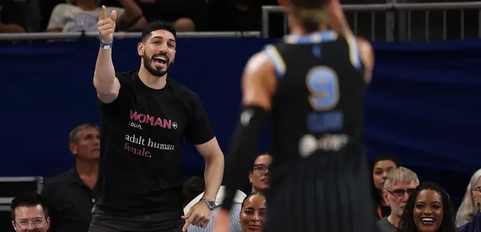 Fan cheering during basketball game with players visible