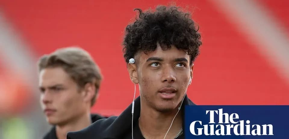 Two young men walking, one wearing earphones