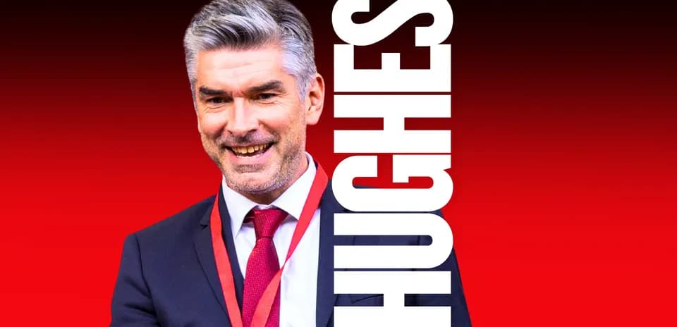 Coach smiling in suit with red background